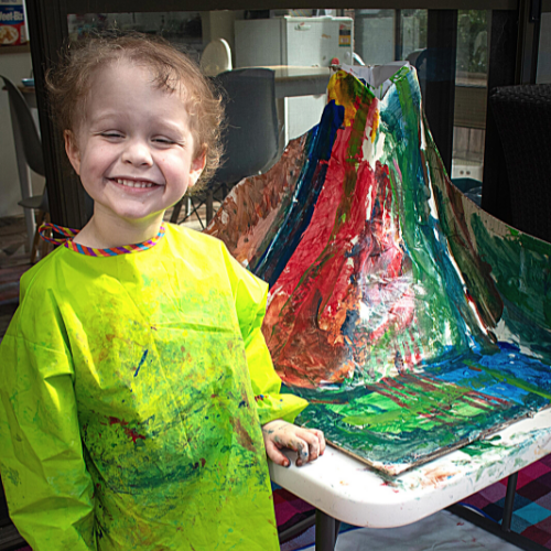 Bradley with a big smile on his face next to a paper mâché volcano