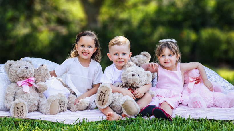 Children with teddy bears on a picnic blanket