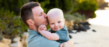 A father doting on his child after release from hospital