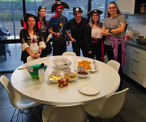 The POA team gather around a snack-filled morning tea table dressed up in their best Pirate attire!