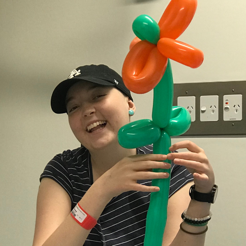 Lexie with an orange flower made out of balloons