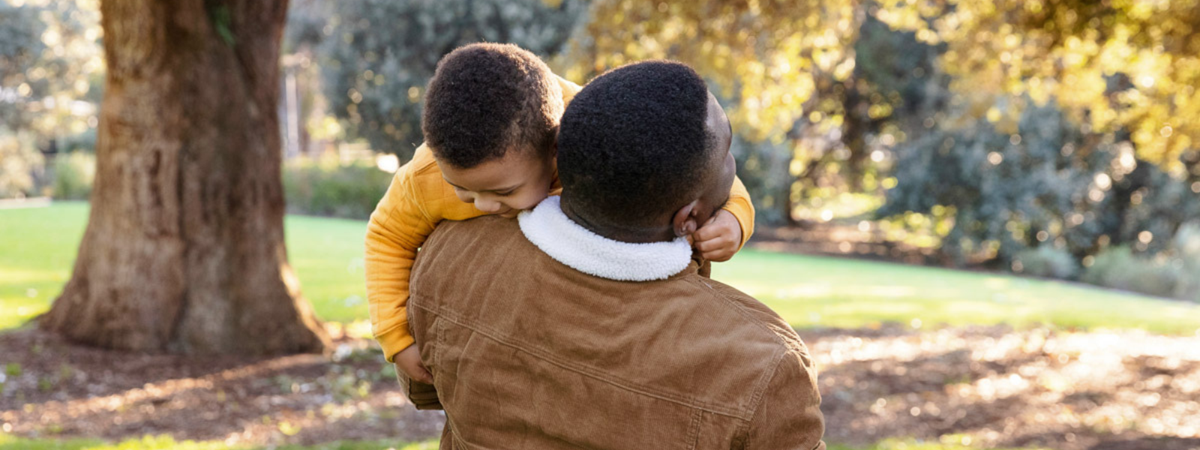 CJ gets carried by his Dad on a walk through the park.