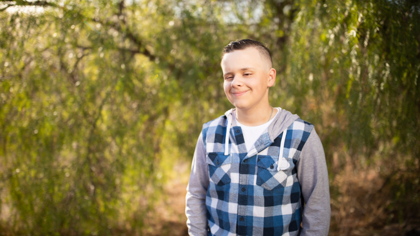 Josh smiles proudly for the camera; behind him is a scenic rural property.